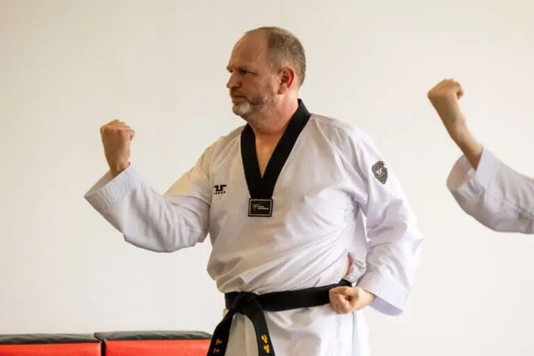 Black belt instructor practices a guarded stance during martial arts training fundamentals