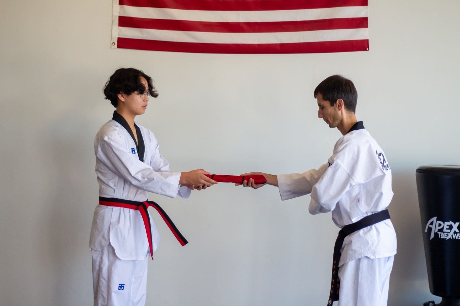 teen receiving a belt after finishing teens taekwondo training